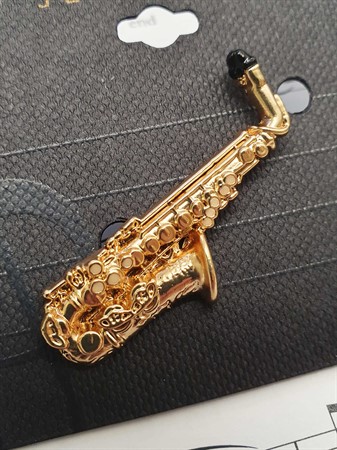 Närbild på guldfärgad Pins Altsaxofon